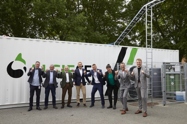 A group photo in front of a shipping container.