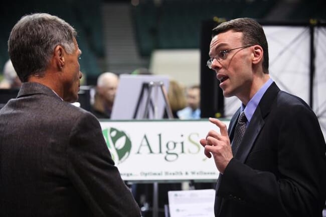 Two men talking at a trade show.