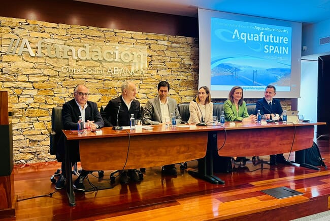 Six people sitting behind a desk.