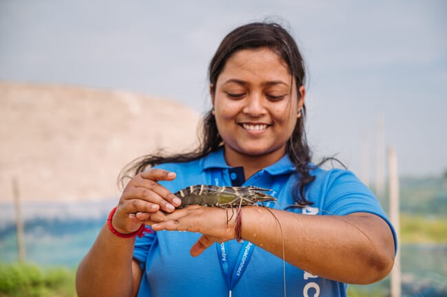 woman balancing a live shrimp on her hand