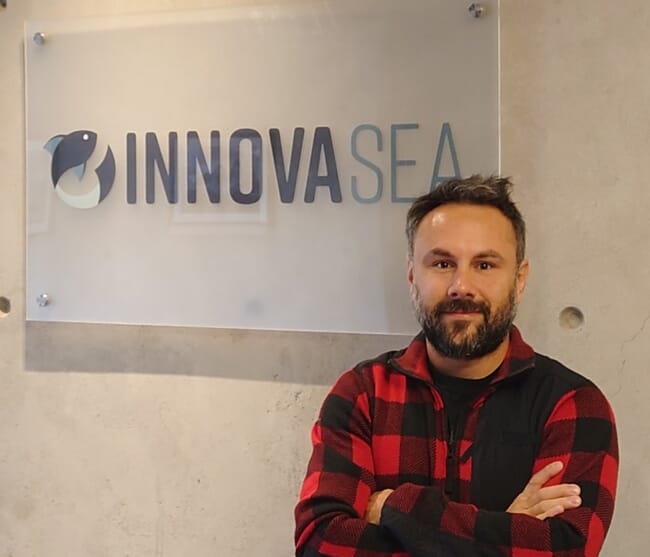 A man standing in front of a sign.