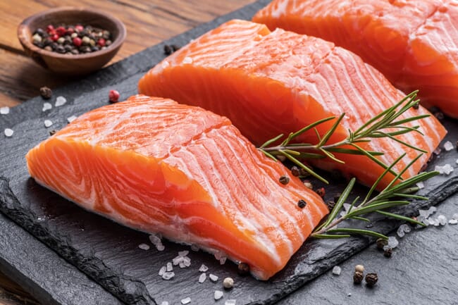 Slices of a salmon fillet on a slate.